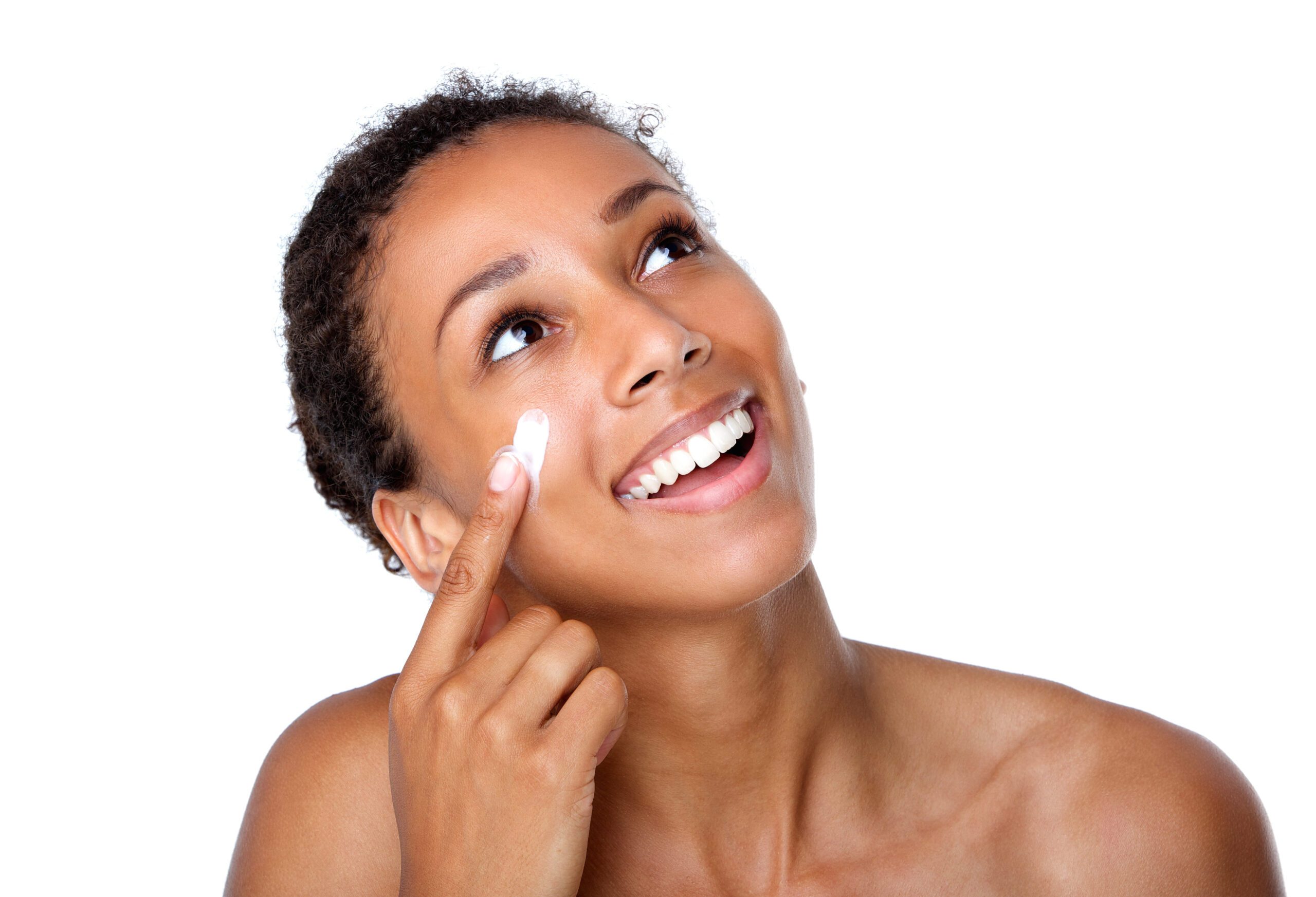 Smiling woman applying lotion on face